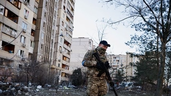 A member of the Ukrainian military surveys an area next to a residential building hit by an intercepted missile, as Russia's invasion of Ukraine continues, in Kyiv, Ukraine March 17, 2022. REUTERS/Thomas Peter