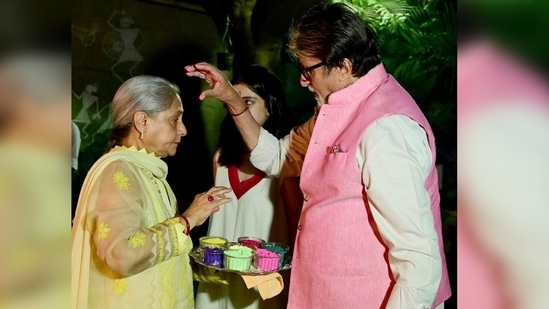 In a picture shared by veteran actor Amitabh Bachchan on his Instagram handle, the actor can be seen applying colour on his wife Jaya Bachchan while their granddaughter Navya Naveli them.(Instagram/@amitabhbachchan)