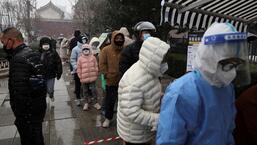 People line up amid snowfall at a mobile nucleic acid testing site, following the Covid-19 outbreak, in Beijing, China, on Friday. (REUTERS)