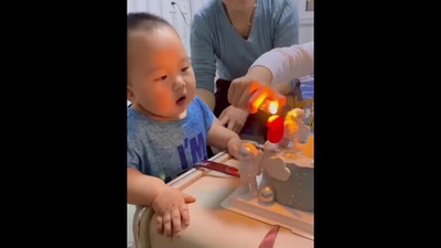 The image shows the kid looking at a candle placed on a birthday cake. (Screengrab)