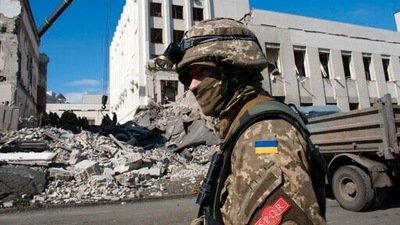 A Ukrainian serviceman guards next to the site of the National Academy of State Administration building damaged by shelling in Kharkiv, Ukraine, Friday. (AP)