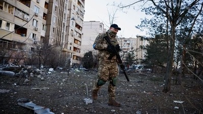 A member of the Ukrainian military surveys an area next to a residential building hit by an intercepted missile, as Russia's invasion of Ukraine continues, in Kyiv, Ukraine. (REUTERS)