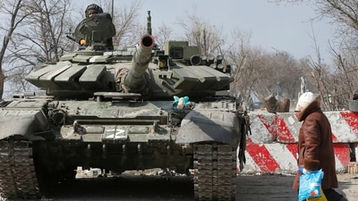 A local resident walks past a tank of pro-Russian troops during Ukraine-Russia conflict in the besieged southern port city of Mariupol, Ukraine March 18, 2022. REUTERS/Alexander Ermochenko (REUTERS)