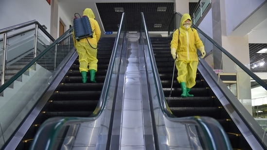 Employees spray disinfectant as part of preventative measures against Covid-19 at the Pyongyang Children's Department Store in Pyongyang.(AFP)