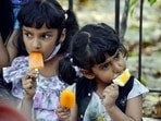 Children eat ice cream on a hot summer day, at Connaught Place, in New Delhi on Saturday. (ANI Photo)
