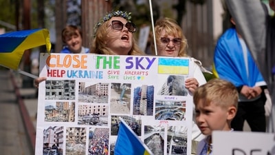 A Ukrainian woman hold a sign with news pictures showing the damage caused to Ukraine from Russia's invasion of the country during a rally in support of Ukraine in Los Angeles Saturday, March 19, 2022. (AP Photo/Damian Dovarganes) (AP) A Ukrainian woman hold a sign with news pictures showing the damage caused to Ukraine from Russia's invasion of the country during a rally in support of Ukraine in Los Angeles Saturday, March 19, 2022. (AP Photo/Damian Dovarganes) (AP)