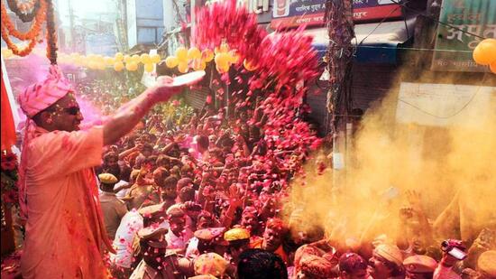 Chief minister Yogi Adityanath showers flower petals on people during the traditional Narsingh Shobha Yatra as part of the Holi festival celebrations, in Gorakhpur on Saturday. (ANI PHOTO)