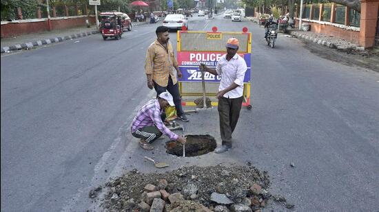 Road cave-in opposite Guru Nanak Stadium in Ludhiana being repaired on March 19, 2022. (Gurpreet Singh/HT)