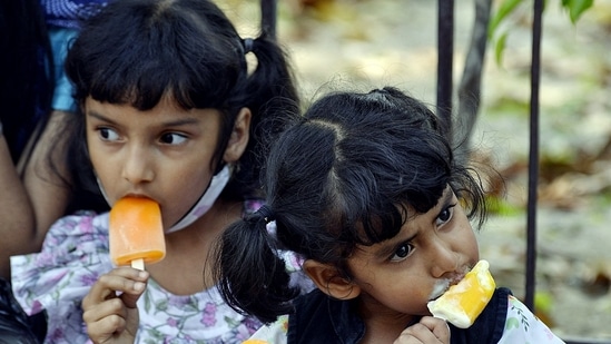 Children eat ice cream on a hot summer day, at Connaught Place, in New Delhi on Saturday. (ANI Photo)