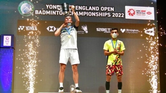 Viktor Axelsen, left, celebrates with his trophy on the podium after his victory over India's Lakshya Sen, right, in their men's singles final match at the All England Open Badminton Championships in Birmingham, England.(AP)