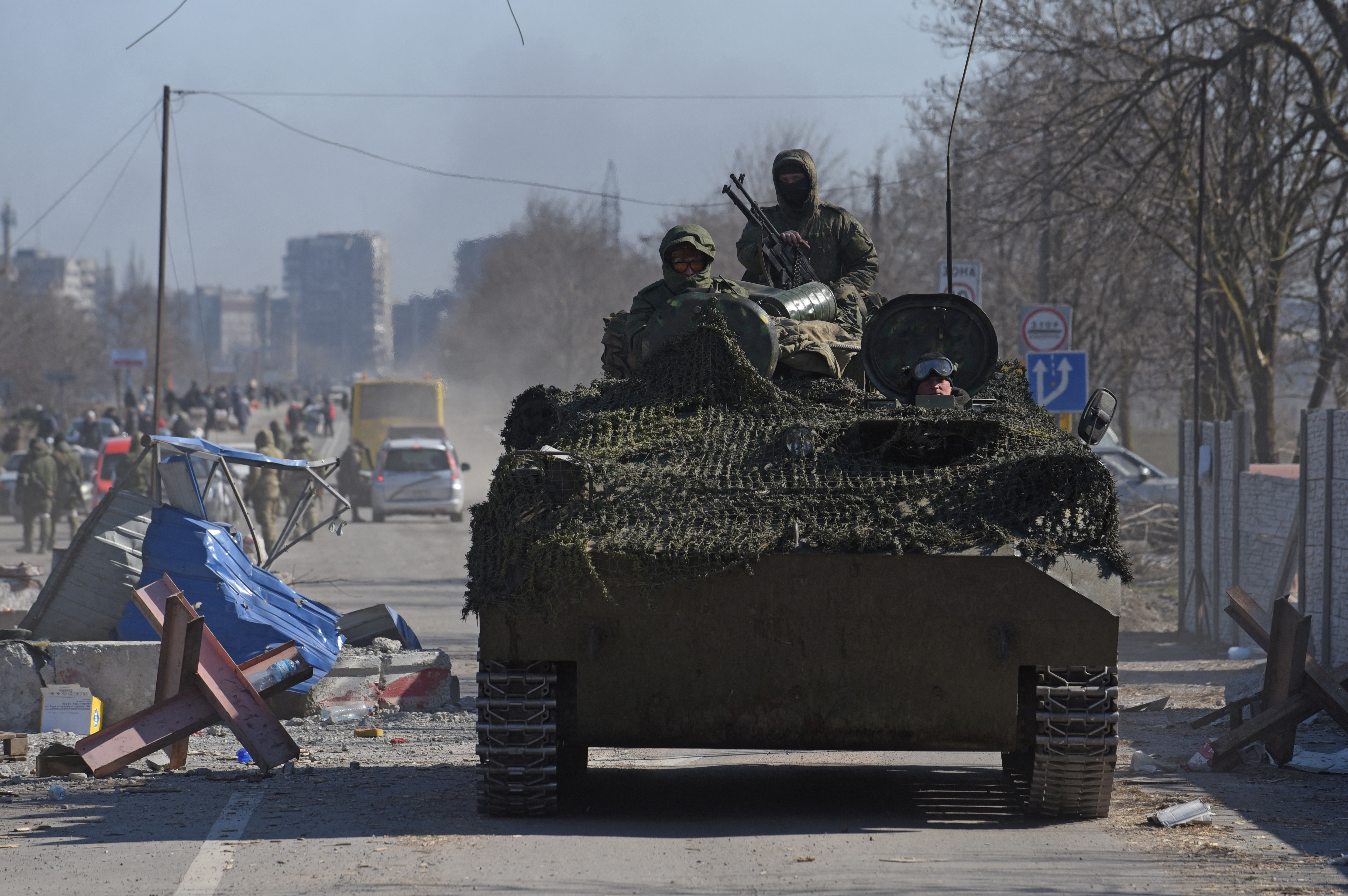 Service members of pro-Russian troops in uniform without insignia drive an armoured vehicle in the besieged southern port city of Mariupol, Ukraine. (REUTERS)