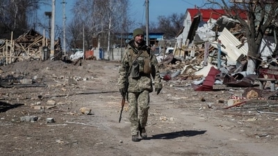 A Ukrainian service member walks, as the Russian invasion continues, in a destroyed village on the front line in the east Kyiv region, Ukraine. (REUTERS)