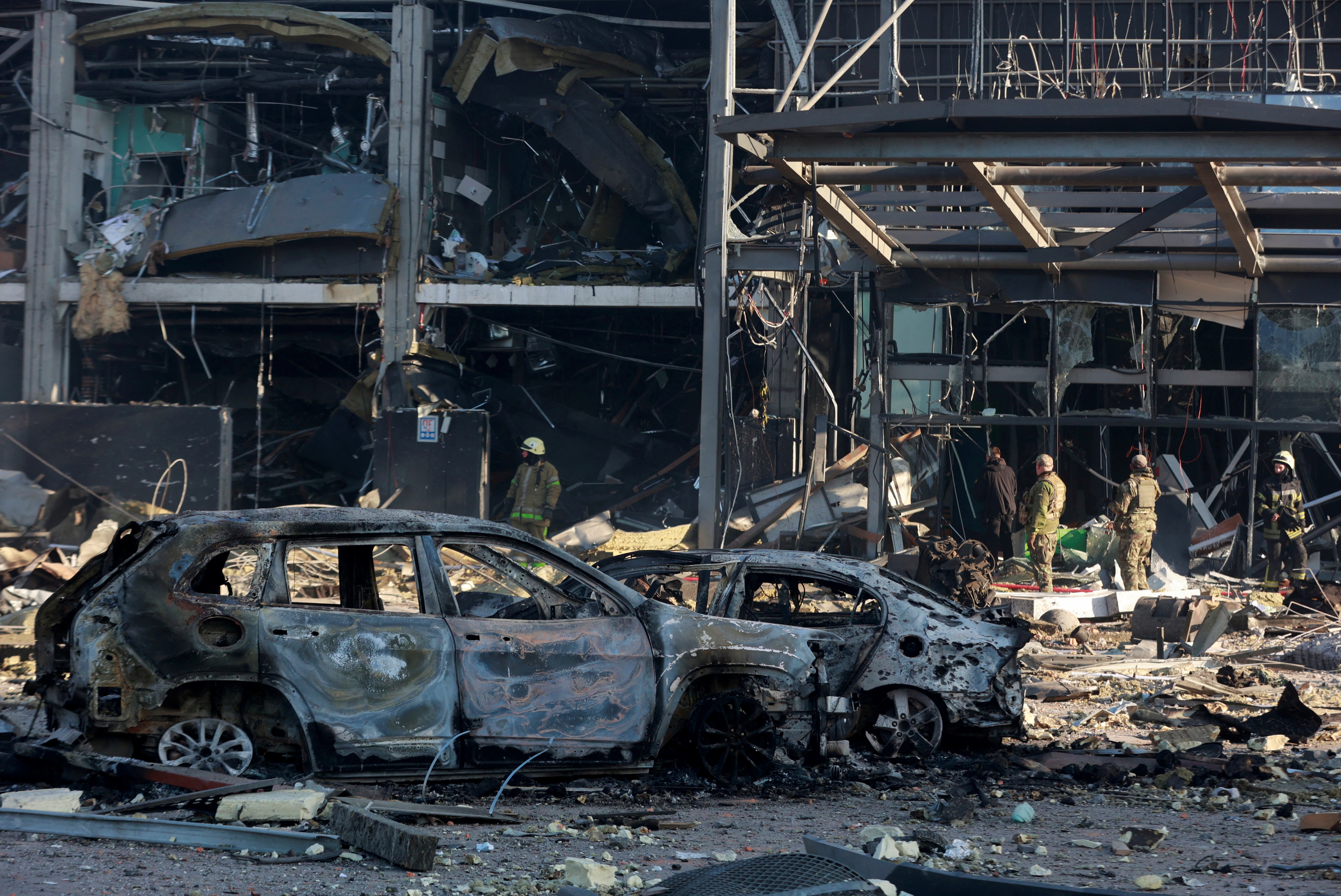 Destroyed cars are seen at the site of a military strike on a shopping center in the Podilskyi district of Kyiv on March 21, 2022.&nbsp; (Reuters photo)