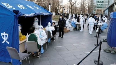 People line up during a mass testing for the coronavirus disease (Covid-19) at a makeshift nucleic acid testing site outside a shopping mall in Beijing, China. (REUTERS)
