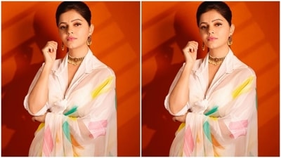 Rubina's saree features colourful geometric prints in yellow, green, orange, and pink hues. She draped it around her body in traditional style and chose a shirt blouse to round it all off. The blouse comes with wide collars, folded sleeves, midriff-baring cropped hem, plunging neckline and a front knot. (Instagram/@rubinadilaik) Rubina's saree features colourful geometric prints in yellow, green, orange, and pink hues. She draped it around her body in traditional style and chose a shirt blouse to round it all off. The blouse comes with wide collars, folded sleeves, midriff-baring cropped hem, plunging neckline and a front knot. (Instagram/@rubinadilaik)