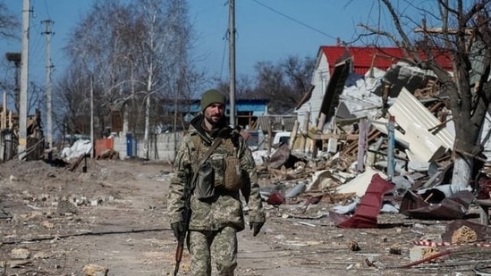 A Ukrainian service member walks, as the Russian invasion continues, in a destroyed village on the front line in the east Kyiv region, Ukraine.(REUTERS)