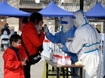 A healthcare worker takes a swab sample from a woman to be tested for the Covid-19 in Beijing. (AFP) A healthcare worker takes a swab sample from a woman to be tested for the Covid-19 in Beijing. (AFP)
