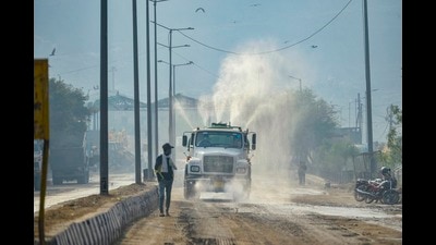 An EDMC vehicle sprinkles water over a road at Ghazipur to contain pollution, New Delhi, November, 23, 2020 (PTI)