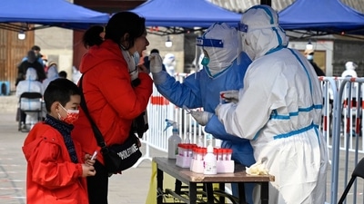 A healthcare worker takes a swab sample from a woman to be tested for the Covid-19 in Beijing. (AFP) A healthcare worker takes a swab sample from a woman to be tested for the Covid-19 in Beijing. (AFP)