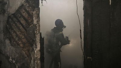 Firefighters extinguish a burning house hit by Russian Grad rockets in Kyiv's Shevchenkivsky district. (AFP) Firefighters extinguish a burning house hit by Russian Grad rockets in Kyiv's Shevchenkivsky district. (AFP)