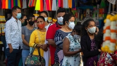 People wearing face masks wait for their turn to enter a church in Mumbai. (AP)