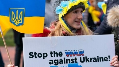 Julia Koch, 10, of Chantilly, Va., holds a flag and sign during a protest against the Russia Ukraine war in Lafayette Park near the White House. (AP) Julia Koch, 10, of Chantilly, Va., holds a flag and sign during a protest against the Russia Ukraine war in Lafayette Park near the White House. (AP)