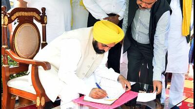 Punjab chief minister Bhagwant Mann signs visitors' book at Hussaniwala (Ferozepur) to pay tributes to Bhagat Singh, Rajguru and Sukhdev on Martyrs' Day, on Wednesday. (ANI)