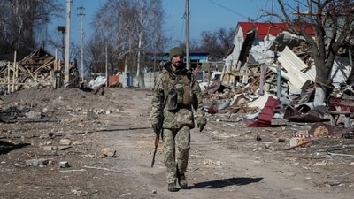 A Ukrainian service member walks, as the Russian invasion continues, in a destroyed village on the front line in the east Kyiv region, Ukraine. (REUTERS)