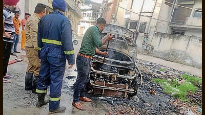 The charred remains of the car in Manna Singh Nagar in Ludhiana on Thursday morning. (HT Photo)