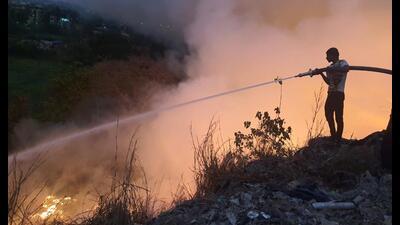 A fire fighter bringing the fire under control after Adharwadi dumping ground in Kalyan caught fire on Thursday. (HT PHOTO)