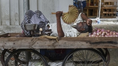 A vegetable seller takes rest on cart as the Chennai city. PTI