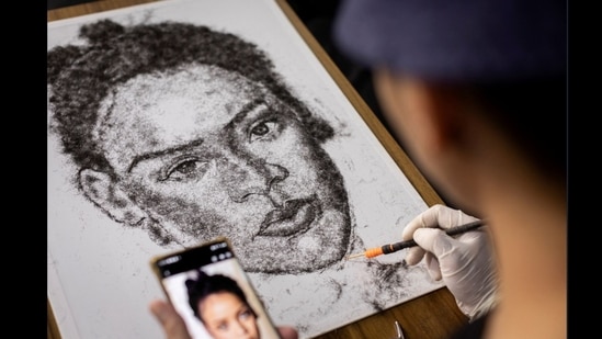 Artist and Filipino seafarer Jesstoni Garcia works on a portrait of Rihanna, made out of human hair, in San Juan City, Philippines. (Reuters)