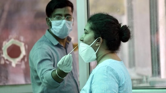 A health worker collects swab samples for Covid-19 test at the district hospital in Noida’s Sector 30 on Saturday. (Sunil Ghosh /HT)