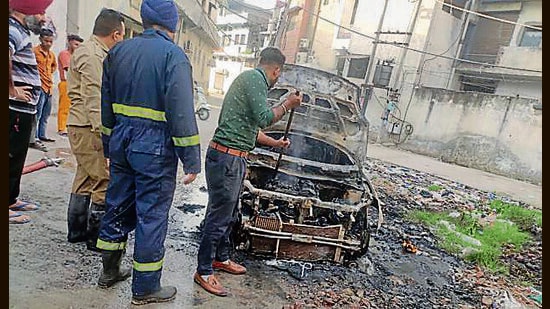 The charred remains of the car in Manna Singh Nagar in Ludhiana on Thursday morning. (HT Photo)