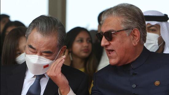 Pakistani foreign minister Shah Mahmood Qureshi (right) speaks with his Chinese counterpart Wang Yi during the Pakistan Day parade in Islamabad on Wednesday. (AFP)