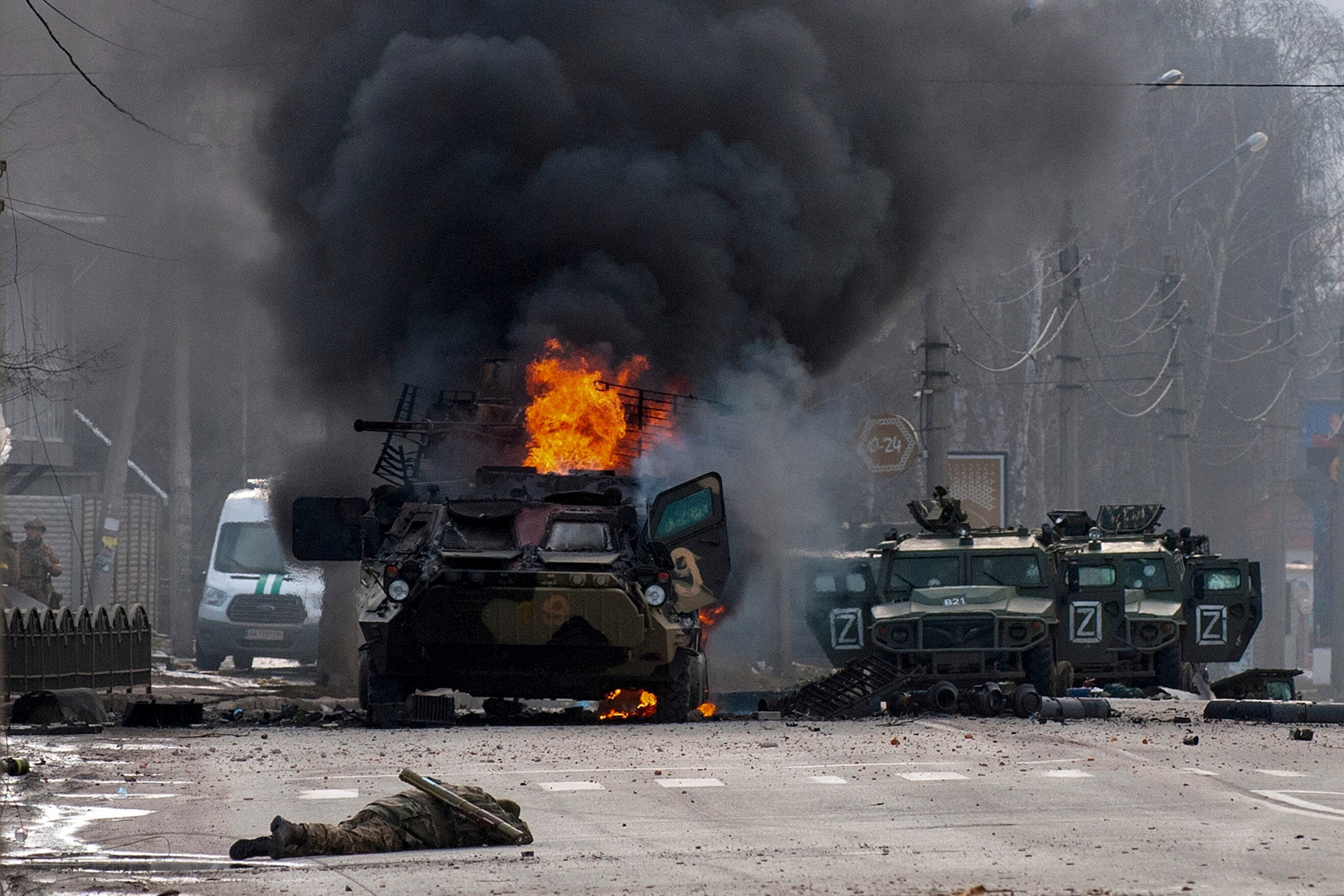 A file photo of a Russian armored personnel carrier burning amid damaged and abandoned light utility vehicles after fighting in Kharkiv, Ukraine (AP)