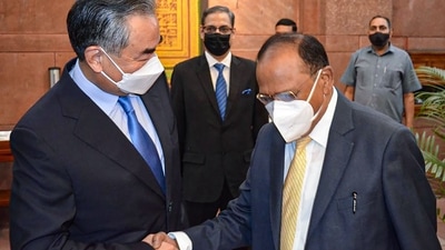 China's Foreign Minister Wang Yi shakes hands with National Security Adviser Ajit Doval, during their meeting, at the South Block, in New Delhi, Friday. (PTI)