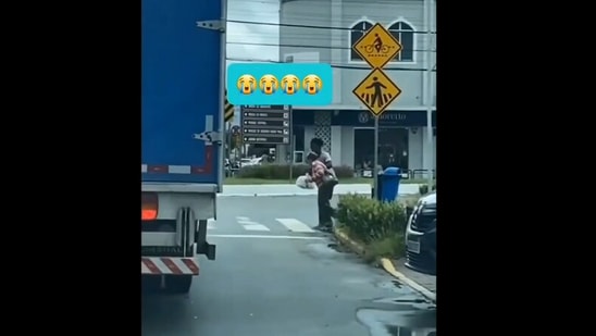 The image, taken from the Instagram video, shows the truck driver helping the elderly woman cross the road. (Instagram/@goodnews_movement)