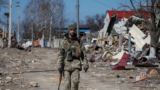 A Ukrainian service member walks, as the Russian invasion continues, in a destroyed village on the front line in the east Kyiv region, Ukraine. (Reuters)