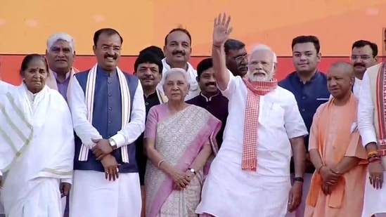 PM Narendra Modi waves at the crowd at Lucknow's Ekana Stadium. Yogi Adityanath, who sworn in as the chief minister of Uttar Pradesh for a record second time and Keshav Prasad Maurya, who took oath as the deputy CM, stand with him on the stage. (ANI Photo)