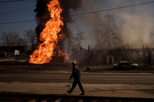 A man walks past flames and smoke rising from a fire following a Russian attack in Kharkiv, Ukraine, on Friday. (AP) A man walks past flames and smoke rising from a fire following a Russian attack in Kharkiv, Ukraine, on Friday. (AP)