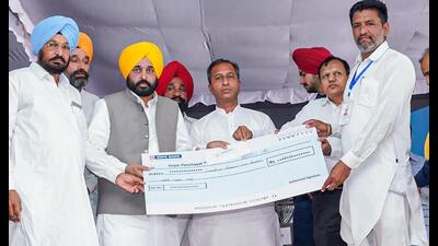 Punjab CM Bhagwant Mann distributing compensation cheques to farmers who couldn’t take their cotton crop to mandis because of damage by pink bollworm. (PTI)