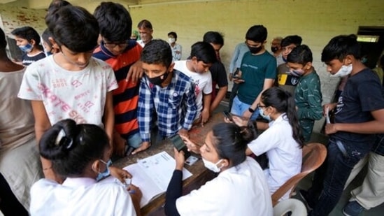 Students register themselves to get vaccinated for COVID-19 during a Vaccination drive for 12 to 14 age group children at a school in Ahmedabad, Friday. (AP Photo/Ajit Solanki)(AP)