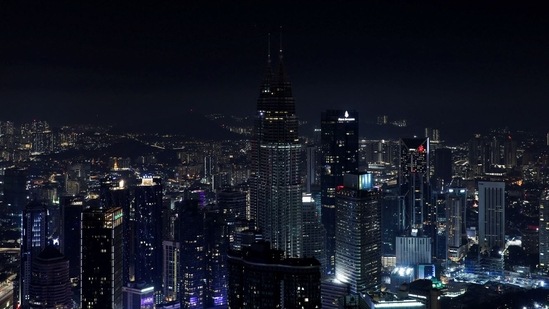 A view of Kuala Lumpur's skyline including Malaysia's landmark Petronas Twin Towers, after the lights were turned off to mark Earth Hour, in Kuala Lumpur, Malaysia, March 26, 2022. (REUTERS/Hasnoor Hussain)
