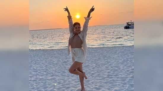 Sunny Leone strikes a happy pose as the sun sets in the backdrop creating a beautiful colour palette in the sky.(Instagram/@sunnyleone)
