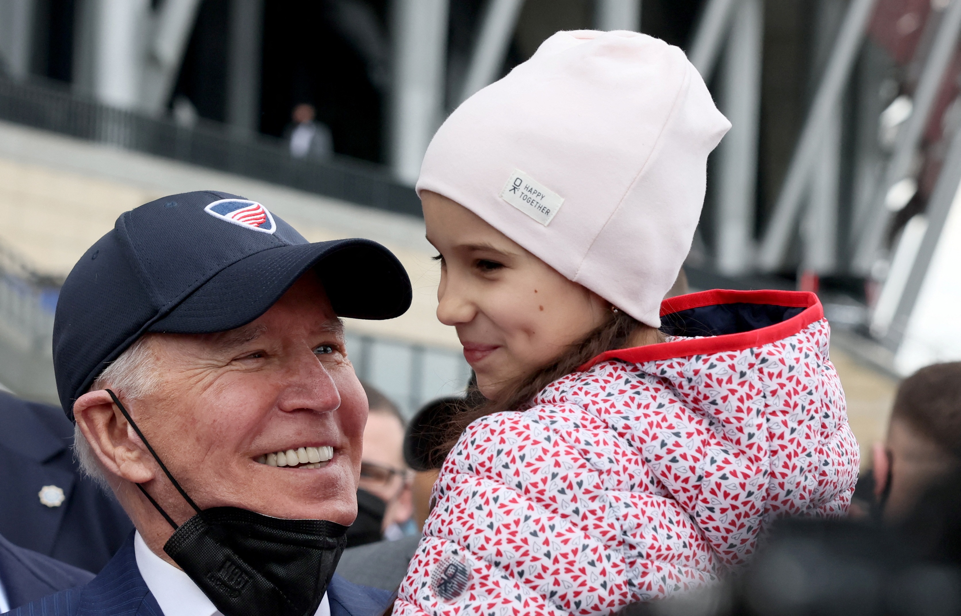 US President Joe Biden holds a child as he visits Ukrainian refugees at the PGE National Stadium, in Warsaw, Poland. (REUTERS)