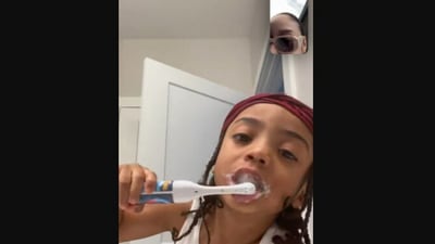 The little boy brushes his teeth in this photo posted on Twitter, with his mom on video call.&nbsp; (twitter/@xo_melss)