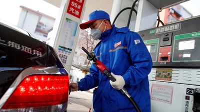 A pump attendant refuels a car at a Sinopec gas station in Beijing, China, (REUTERS)