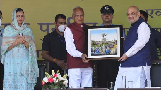 Punjab governor and UT administrator Banwarilal Purohit (centre) presenting a memento to Union home minister Amit Shah (right) in the presence of city mayor Sarabjit Kaur (left) at the football ground in Sector 17, Chandigarh, on Sunday. (Keshav Singh/HT)