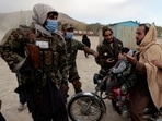 Taliban fighters talk to a man riding a motorcycle with his children as they visit the amusement park at Kabul’s Qargha reservoir, Afghanistan. Taliban fighters talk to a man riding a motorcycle with his children as they visit the amusement park at Kabul’s Qargha reservoir, Afghanistan.